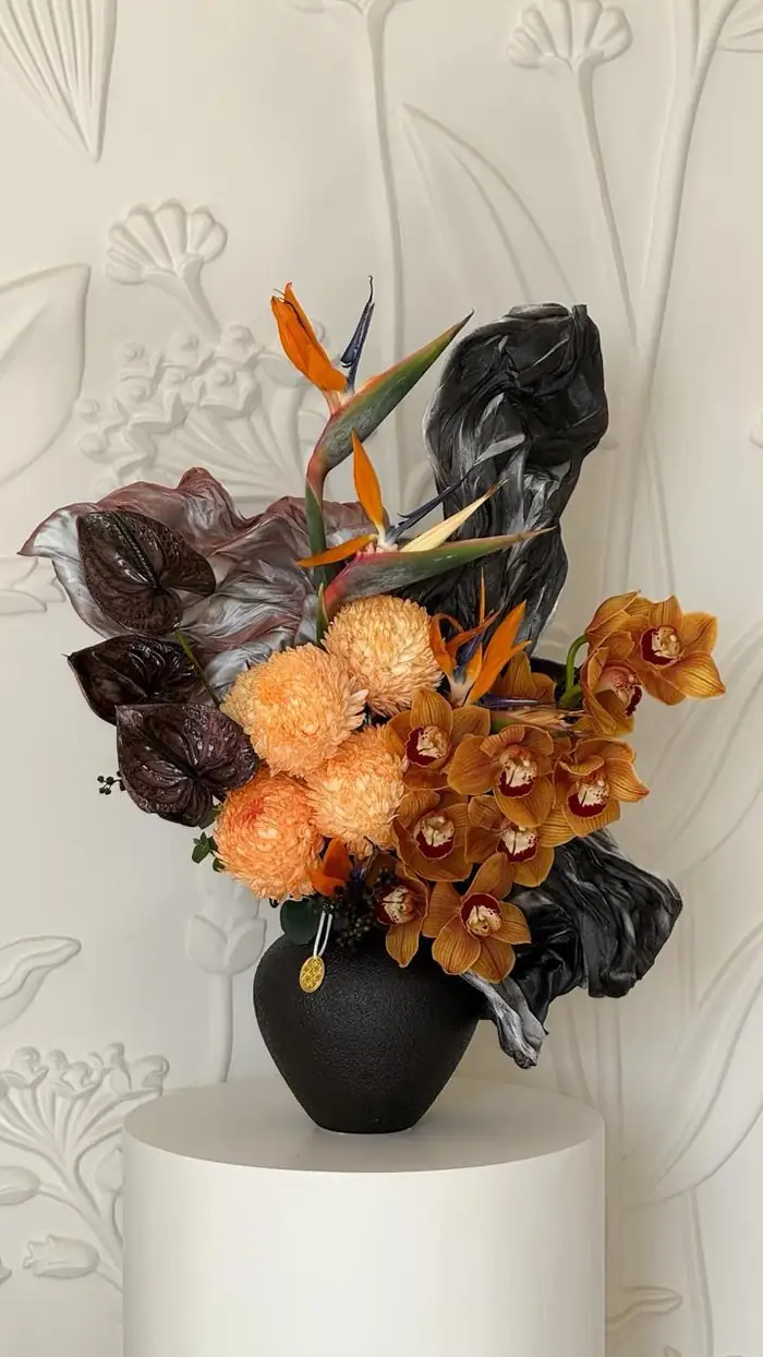 Tall dark arrangement on a black plinth