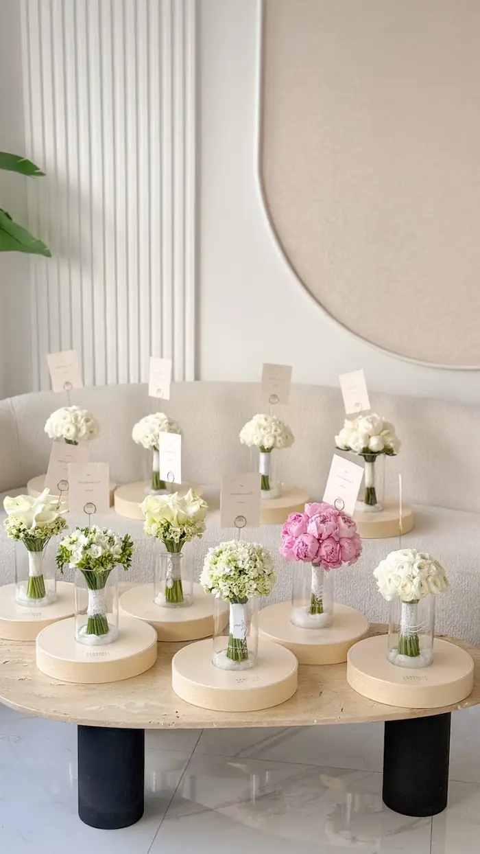 Small glass vases of roses with name cards